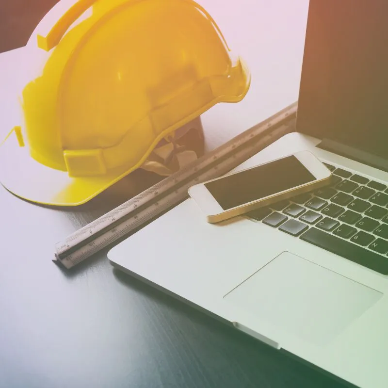 Caschetto, computer, telefono e righello